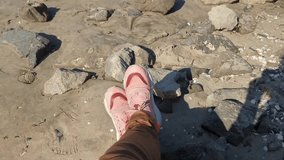 A smooth transition from feet in sneakers on a sandy beach to sea views and clear blue skies on a clear sunny day. Reals style video for social media