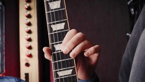 Electric guitar strings, close up. Vertical video. Musical instruments. Guitarist playing chords on guitar on stage. Musician performing song on guitar at rehearsal studio. Music concept