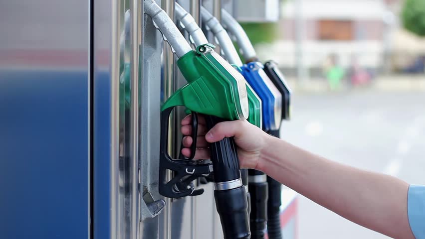 Hand Putting Back Gasoline Nozzle into its Place After Car Refueling at Gas Station. Filling Up the Gas Tank. Close-up of a Man's Hand Using a Fuel Nozzles. Gasoline and Diesel Fuel Prices Update.
