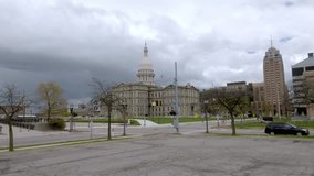 Michigan State Capitol building in Lansing, Michigan with drone video moving low.