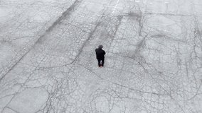Man walking in a downtown Lansing, Michigan parking lot with drone video following above.
