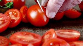 Sharp knife delicately slicing ripe cherry tomatoes showing interior texture. - Powered by Shutterstock - Get 15% off with code: PIKWIZARD15