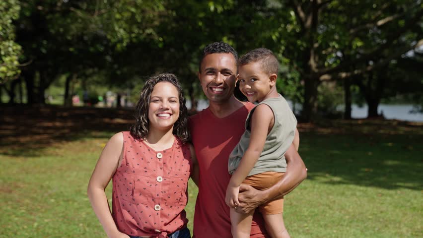 Latino family of mother, father and son standing at city park and smiling in front of the camera. Portrait shot. Outdoors
 Royalty-Free Stock Footage #1103952991