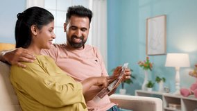 Happy Indian Pregnant women or wife with caring husband checking ultrasound scan reports at home - concept of Parenthood journey, bonding and Expectant parents - Powered by Shutterstock - Get 15% off with code: PIKWIZARD15