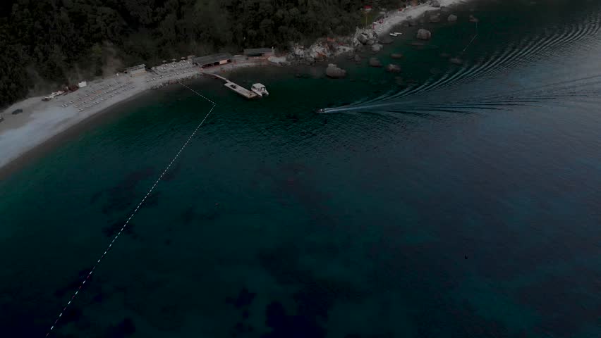 Water Taxi Arriving At Jaz Beach From Budva In Montenegro. aerial tilt-up
