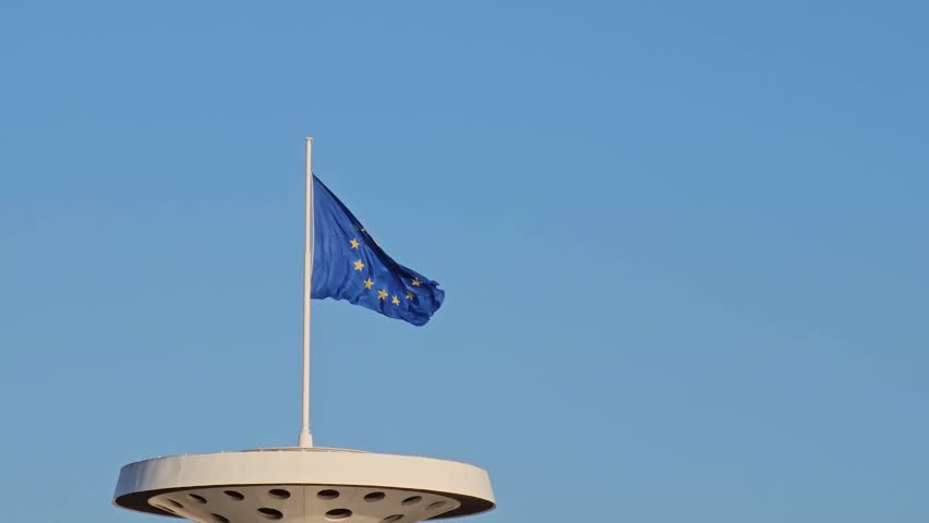 EU flag. The flag of the European Union flutters in the wind against a blue sky in Lyon, France. | Shutterstock HD Video #1103954247
