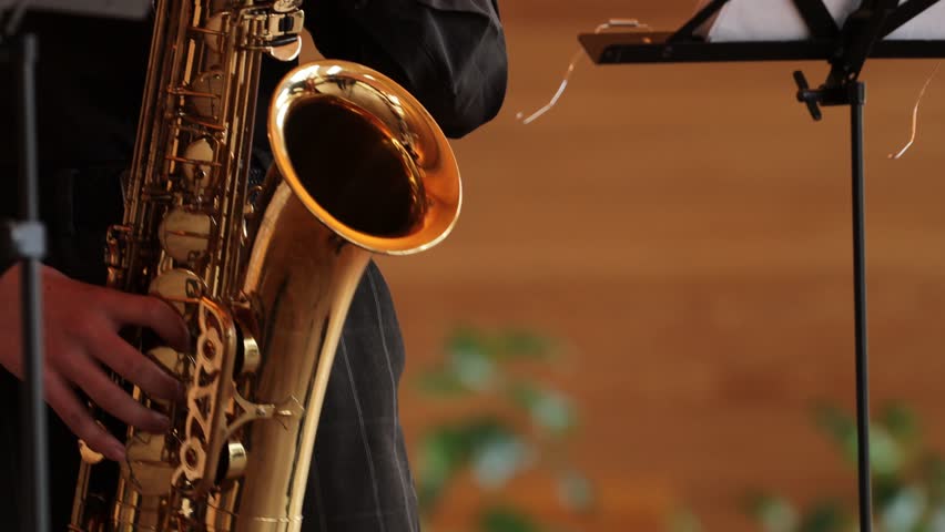 saxophonist in black suit playing the saxophone