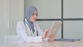 Online Video Chat on Tablet by Muslim Female Doctor in Clinic