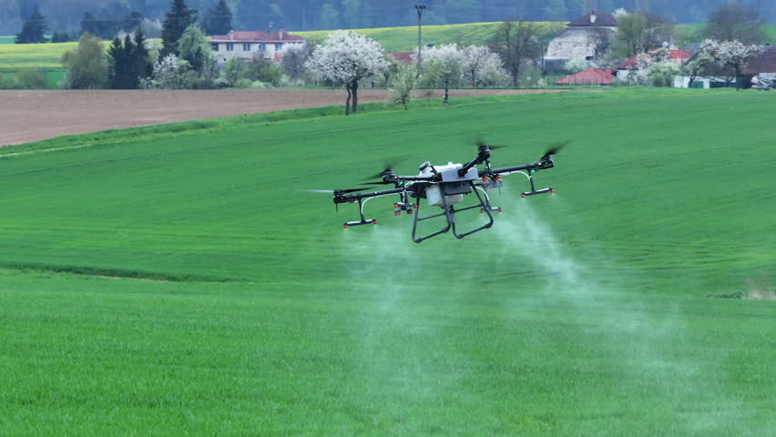 Agriculture Drone Flying Above Green Farming Field and Spraying Fertilizer, Modern Farming Concept, Tracking Shot Royalty-Free Stock Footage #1103960117