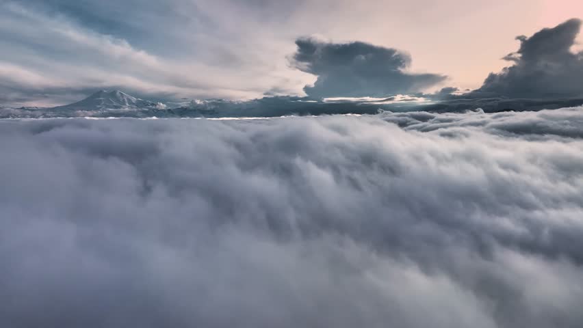 Flying over evening clouds with a late sun. Flight through moving clouds with beautiful sunset rays. Ideal for cinema, background, digital composition Royalty-Free Stock Footage #1103961235