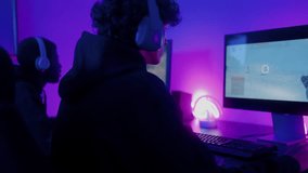 Gamer teenager playing online video game inside gaming room - Technology trend concept