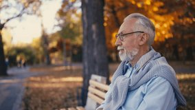 Stylish senior man feeling happy sitting on bench in public park, wellbeing - Powered by Shutterstock - Get 15% off with code: PIKWIZARD15