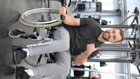 Vertical video of a man in a wheelchair working out in the gym during rehabilitation.