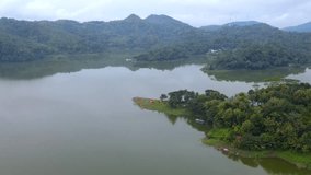 Lake with green water and green trees. Reflection in the water. Beautiful spring landscape with forest and hill. Forest and lake. Aerial View. Drone shot over beautiful lake surrounded with forest