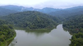 Aerial view of two large rivers that estuary into a lake surrounded by forest. Reflection in the water. Beautiful landscape with hill and lake. Forest and lake in foggy morning - 4K drone footage