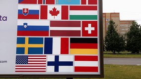 Many national country flags printed on a billboard against a Hospital building in a European city