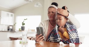 Unaltered african american mother and sick daughter using phone for doctor video call, slow motion. Lifestyle, family, healthcare, telemedicine, communication and domestic life.