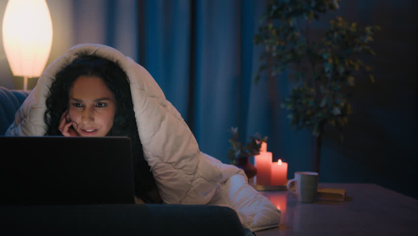 Excited shocked Indian woman amazed wonder Hispanic girl shock surprised astonish stunned watching movie reading news in laptop social media addict at night evening home on couch under blanket cover Royalty-Free Stock Footage #1103983587
