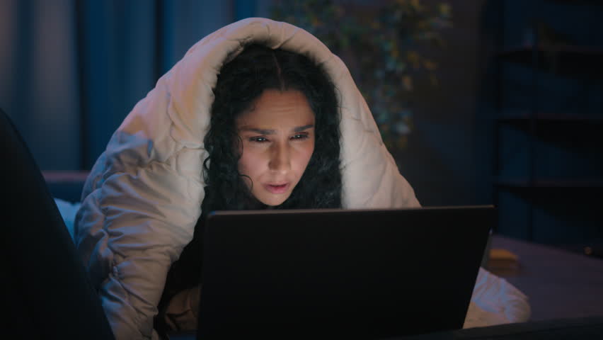 Tired Hispanic girl exhausted sleepy woman fatigued Indian Arabian female at night evening home couch sofa under blanket cover duvet working with laptop watching movie computer addict yawn need sleep Royalty-Free Stock Footage #1103983589