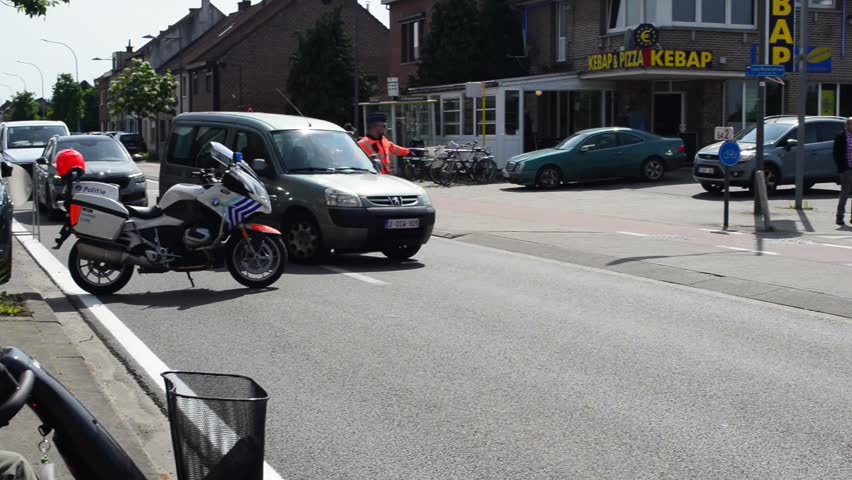 Wilsele, Vlaams-Brabant, Belgium - May 18, 2023: free entry to the local annual Ladies Elite cycling race for women. BMW 1250 cc police motorcycle as a roadblock sporting event. Peugeot drives back