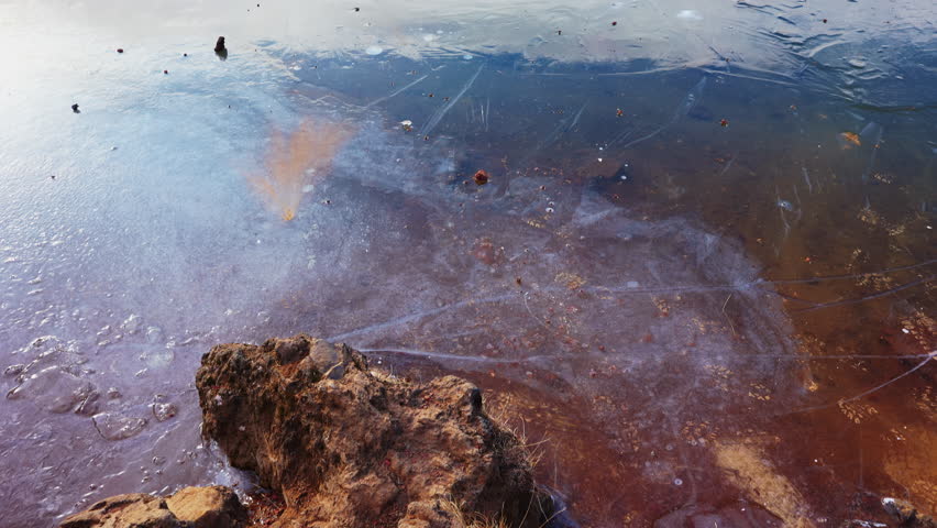 Spectacular frozen lake with hills in icelandic landscape, massive vulcanic crater with water and red rocks. Nordic natural scenery with snow and ice, scandinavian landcapes in iceland.