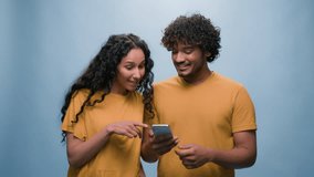 Multiracial couple with mobile phone shopping online discuss woman and man choosing goods booking tickets order delivery thumbs up courting purchase combined family budget in blue studio background - Powered by Shutterstock - Get 15% off with code: PIKWIZARD15