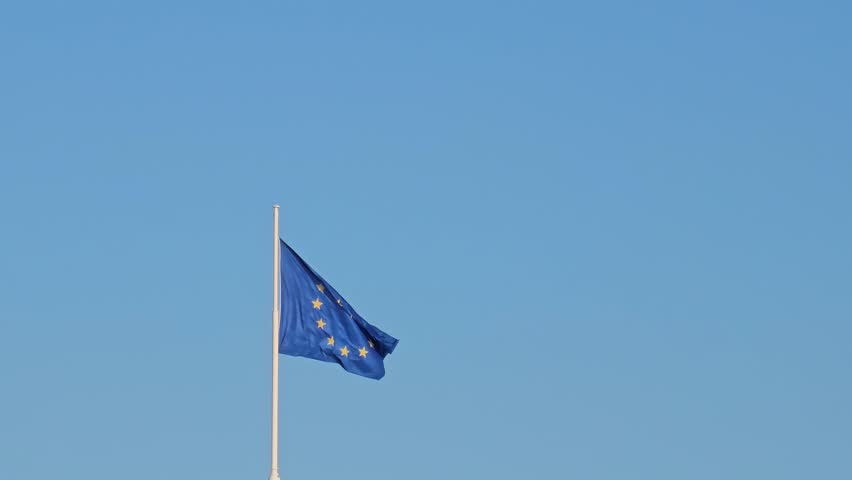 EU flag. The flag of the European Union flutters in the wind against a blue sky in Lyon, France. | Shutterstock HD Video #1103990235