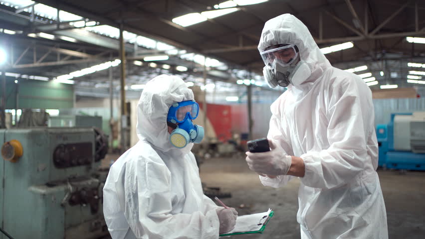 Team of scientist wearing a chemical protection suit and high efficiency filter face mask working in the bio - chemical contaminated factory. Bio chemical scientists working in the hazardous area. Royalty-Free Stock Footage #1104002465