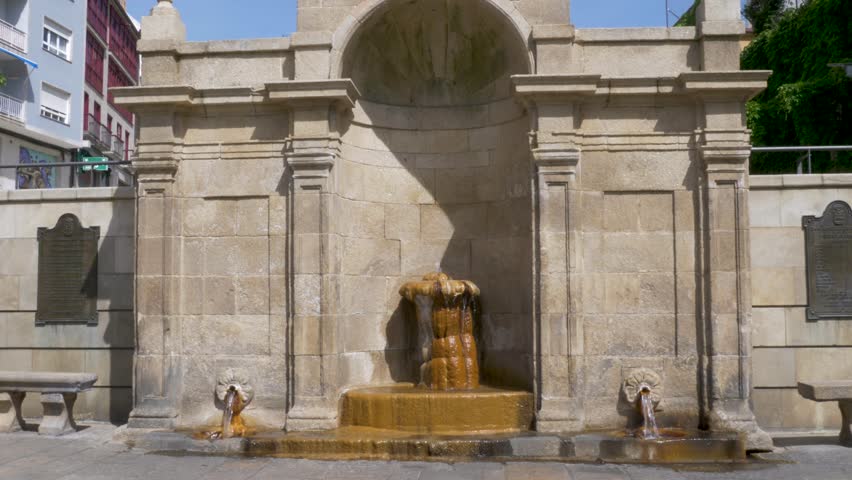 Wide static shot of a stone built thermal water source in As Burgas hot springs in Ourense, Spain