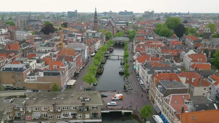 This aerial drone video shows the beautiful old city of Leiden, Zuid-Holland, the Netherlands. In this shot you can see some canals with typical dutch canal houses. 