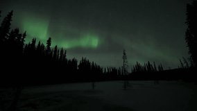 Astonishing, amazing northern lights aurora borealis seen in Yukon Territory, northern Canada. Timelapse video of aurora bands moving across the north sky with green colours. 	