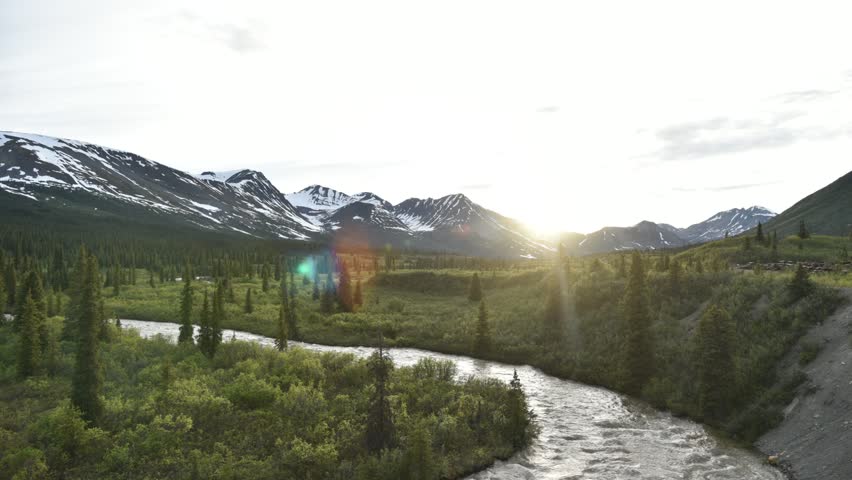 Sunset timelapse view in northern Canada, arctic area on summer solstice with sun dipping down behind the magnificent mountains. Taken on MacMillian River. 