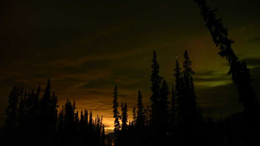 Sunset views in northern Canada with aurora borealis starting to show. Clouds moving across the northern arctic sky during fall season. 