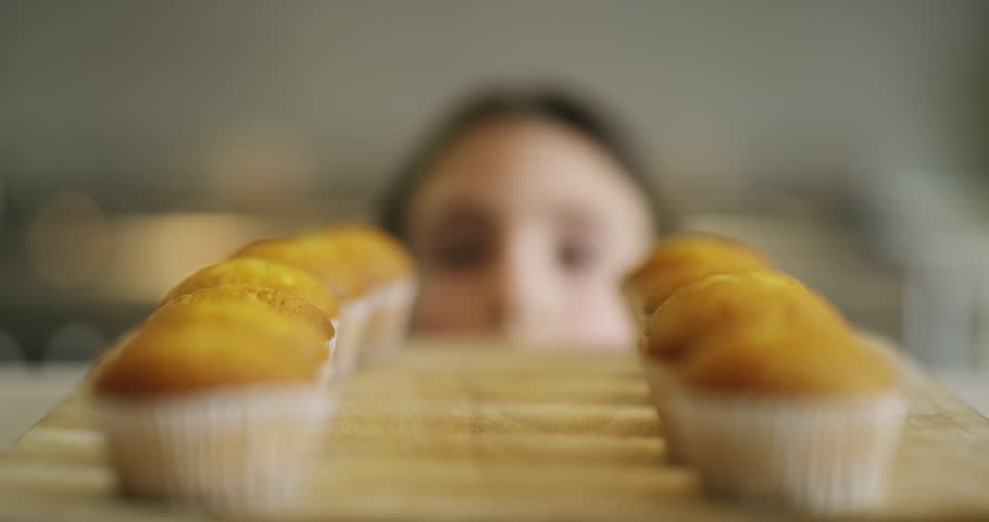 Girl, kitchen and kid stealing food, dessert or baked cupcake on counter and hungry for sugar. Naughty, child and cheat on diet, nutrition and secret eating of sweet homemade muffin on table Royalty-Free Stock Footage #1104011053