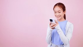 Smiling Asian woman in casual clothes looking at smartphone app using mobile phone.