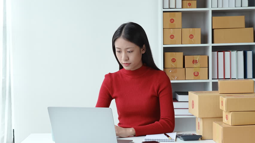 e-commerce, small business, sme , beautiful Asian woman expressing stress and frustration after watching online product sales at computer to fail meet planned, burnout syndrome concepts. Royalty-Free Stock Footage #1104016023