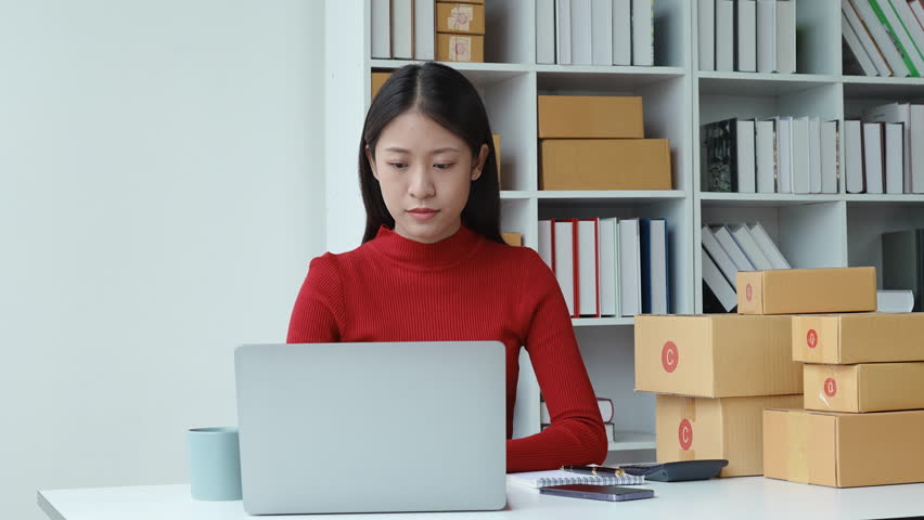 e-commerce, small business, sme , beautiful Asian woman expressing stress and frustration after watching online product sales at computer to fail meet planned, burnout syndrome concepts. Royalty-Free Stock Footage #1104016027