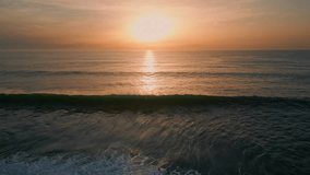 Sunrise sea surf washing beach drone view. Golden dawn sky over dark serene ocean water surface. Picturesque swell peaceful waves moving at morning sundown slow motion. Meditative calm marine scenery  - Powered by Shutterstock - Get 15% off with code: PIKWIZARD15