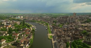 Establishing shot of the French center of the medieval city of Auxerre which is separated by the Yonne river. Red roofs of historic, ancient houses in France. Burgundy is oldest regions of France
