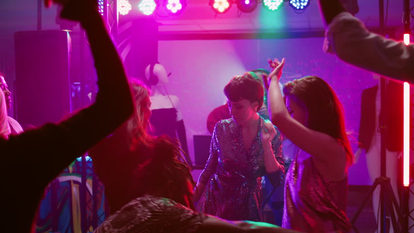 Funky people showing cool dance moves on electronic music, having fun with friends at social gathering. Men and women enjoying disco party on dance floor, entertainment. Handheld shot. | Shutterstock HD Video #1104023459