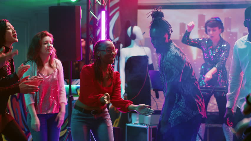 African american person having fun, dancing in the club at social gathering with funky people. Cheerful group of friends listening to music, enjoying party on the dance floor. Tripod shot. | Shutterstock HD Video #1104023461