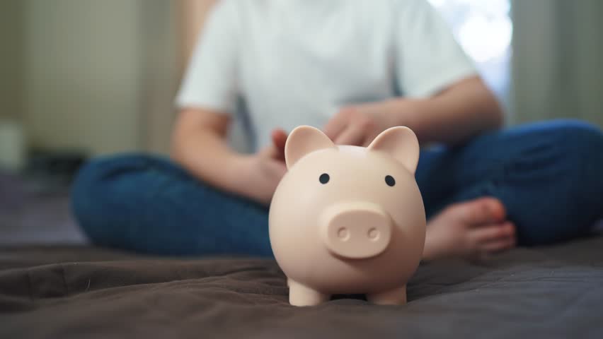 child hands hoarding coins put in piggy bank. happy family accumulation business concept. child saving coins in a piggy bank dream close-up. child hands puts coins in a large piggy bank indoors Royalty-Free Stock Footage #1104028061