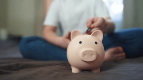 child hands hoarding coins put in piggy bank. happy family accumulation business concept. child saving coins in a piggy bank dream close-up. child hands puts coins in a large piggy bank indoors - Powered by Shutterstock - Get 15% off with code: PIKWIZARD15