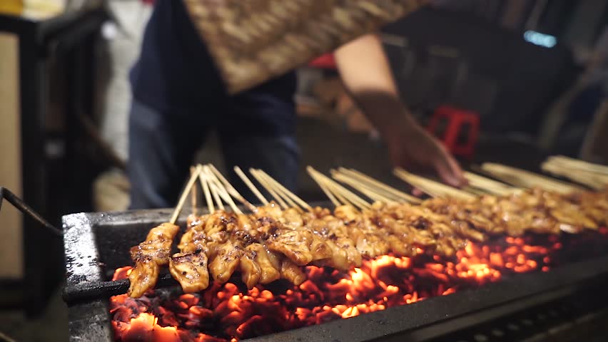Madura chicken satay is again grilled on the grill from the front view