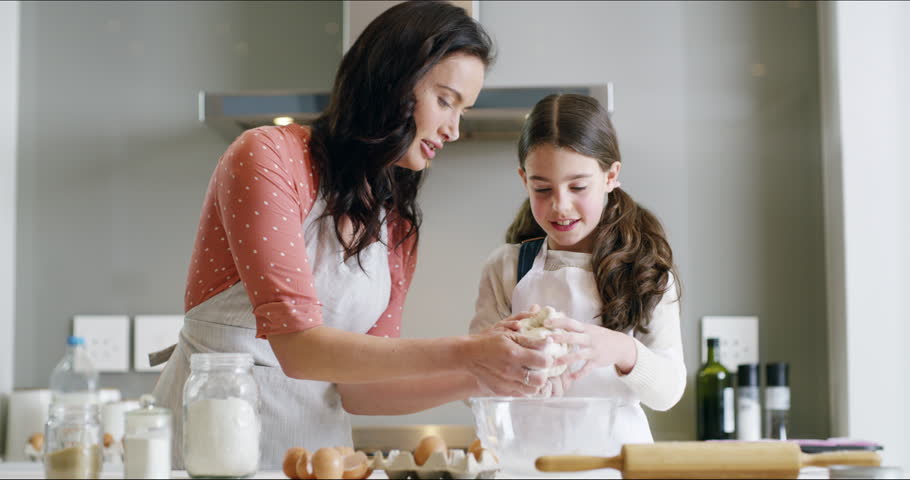 Bake, family and a mama with her daughter learning about cooking in a kitchen for child development. Baking, children and ingredients with a mother showing her young female kid how to knead dough Royalty-Free Stock Footage #1104030871