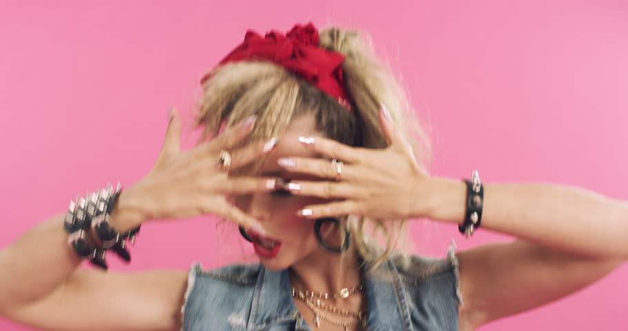 Dance, 80s fashion and face of a woman isolated on a pink background in a studio. Makeup, retro and portrait of a dancing vintage girl with punk clothes, style and looking old school on a backdrop