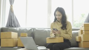 Asian businesswoman selling online and checking product packages
Receive orders on laptop, phone and take notes on transport packages. Home office female entrepreneur (SME business)
