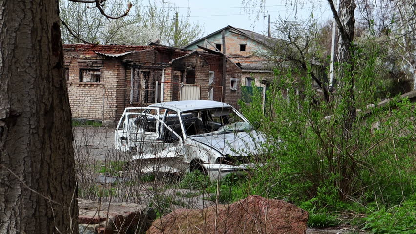 Consequences of the bombing in the city. The rocket blew up the house. A bombed-out apartment building and burnt-out cars after an airstrike. Holes in the walls from shells. Remains of property.