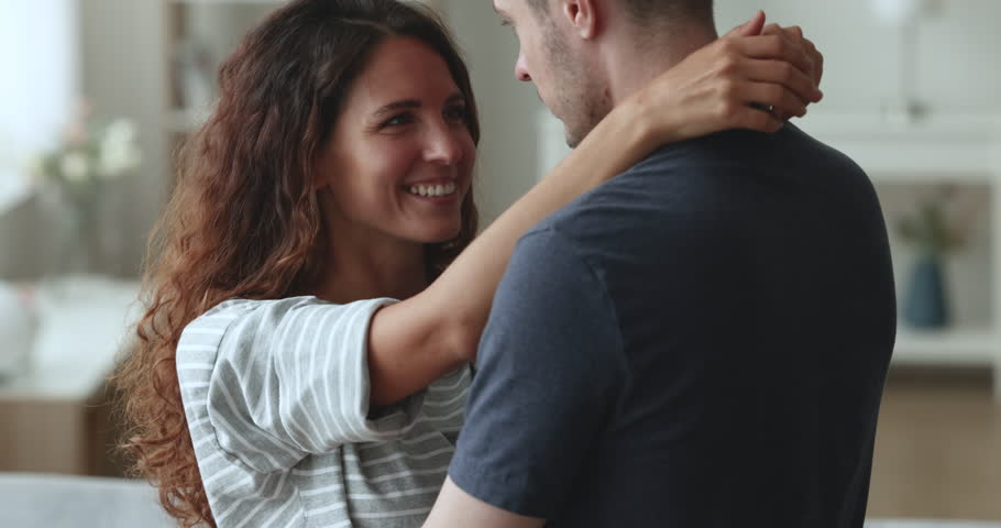 Close up of cheerful wife and husband hugging moving to the music feel happy spend romantic date. Harmonic relationships, happy marriage, understanding, family couple enjoy leisure on weekend at home Royalty-Free Stock Footage #1104040043
