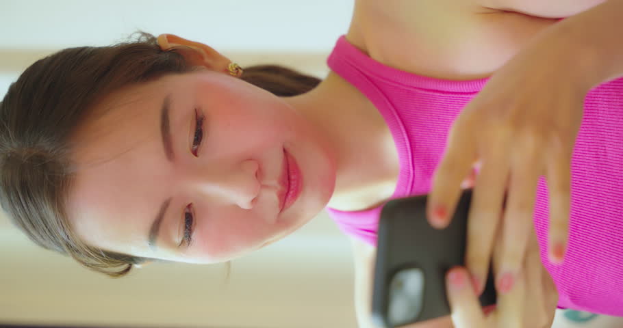 Asian woman using in smartphone in restaurant. She using phone for work or search data with smile.